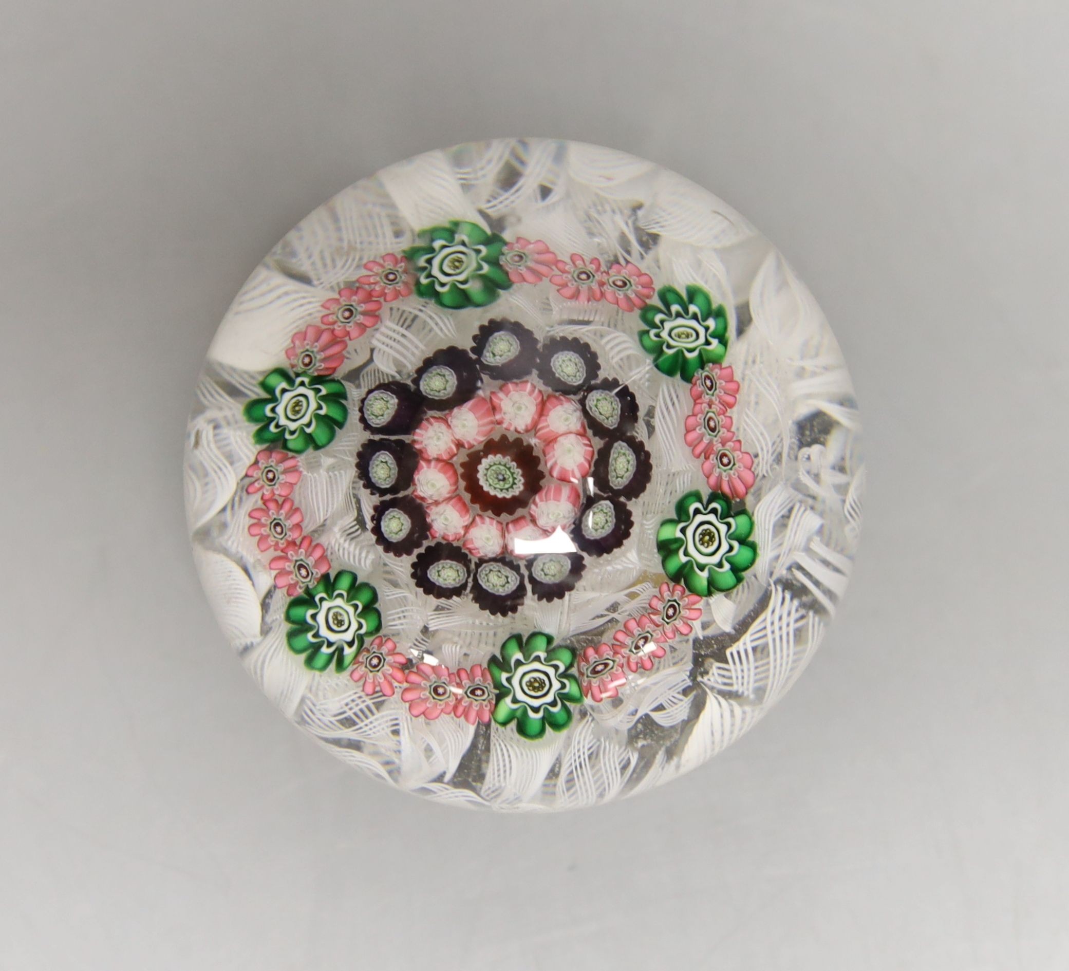 A mid 19th century French concentric millefiori glass paperweight, with scrambled latticino ground